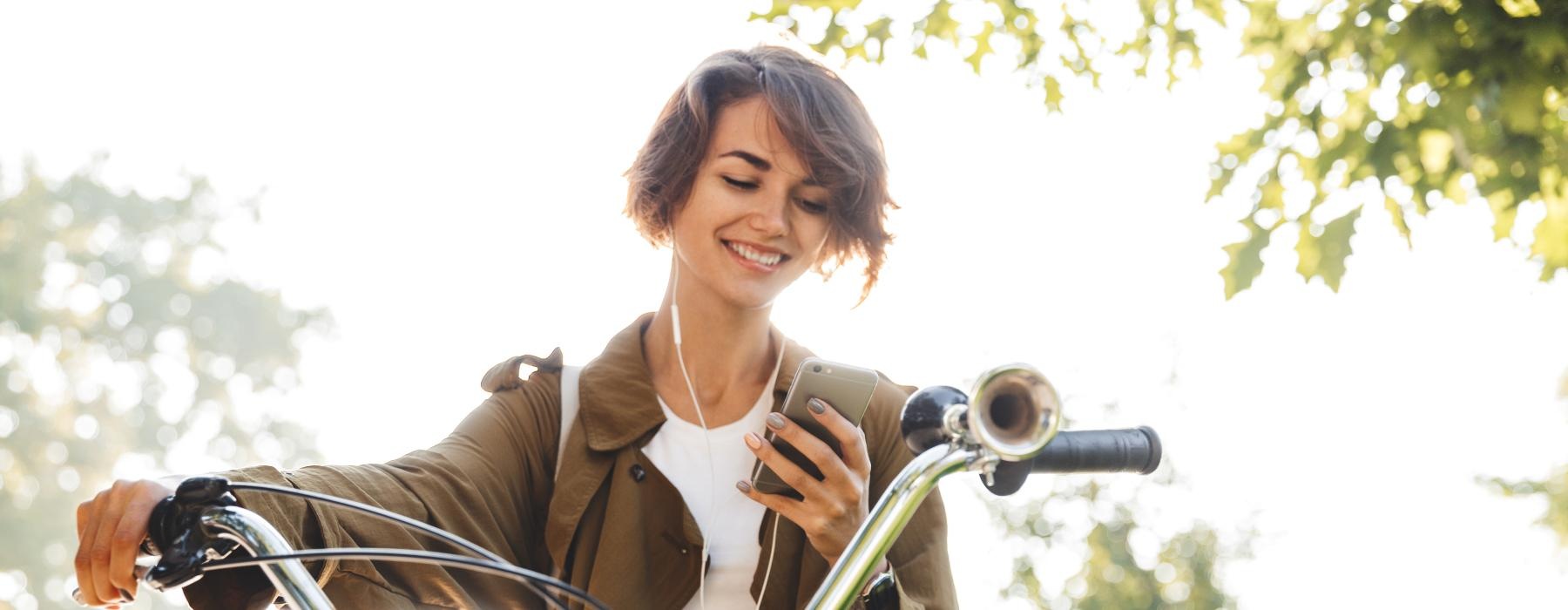 a person sitting on a bike looking at their phone